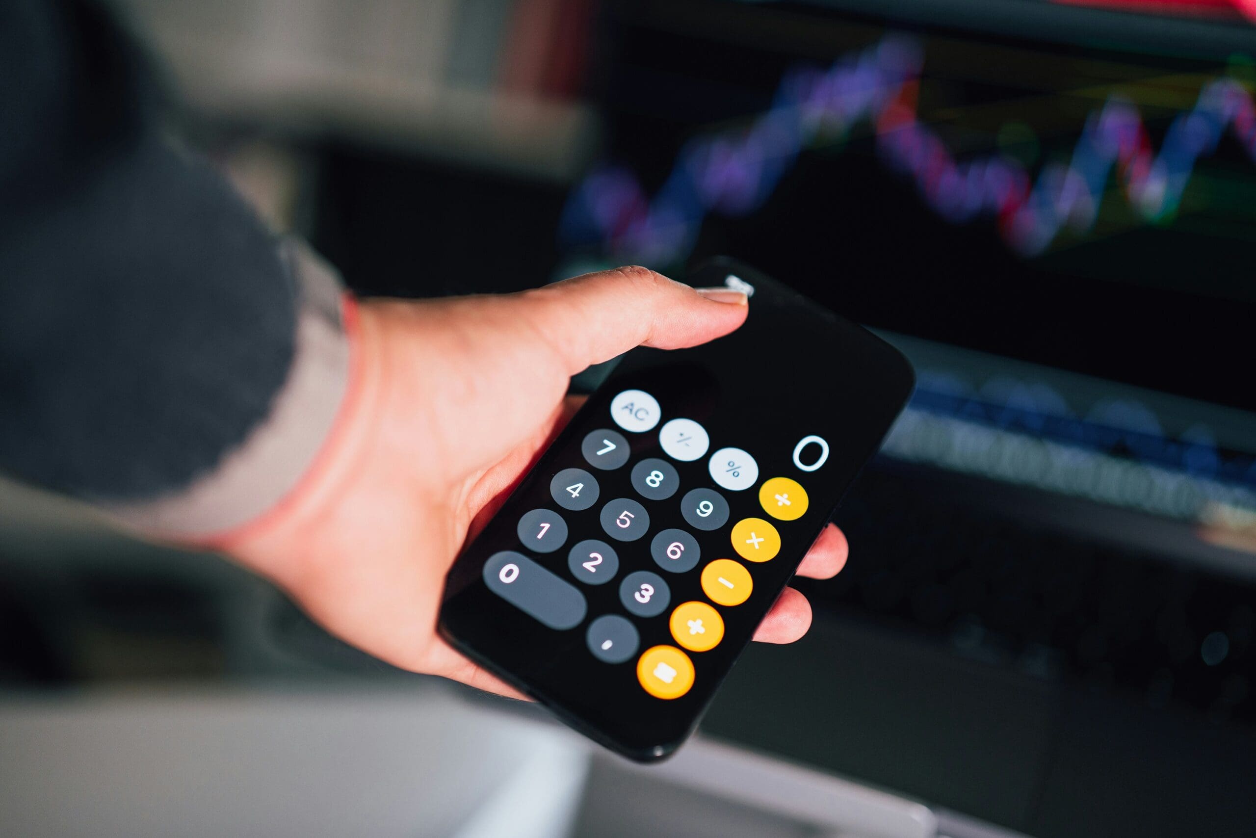 person holding phone calculator showing number zero to depict net-zero emissions