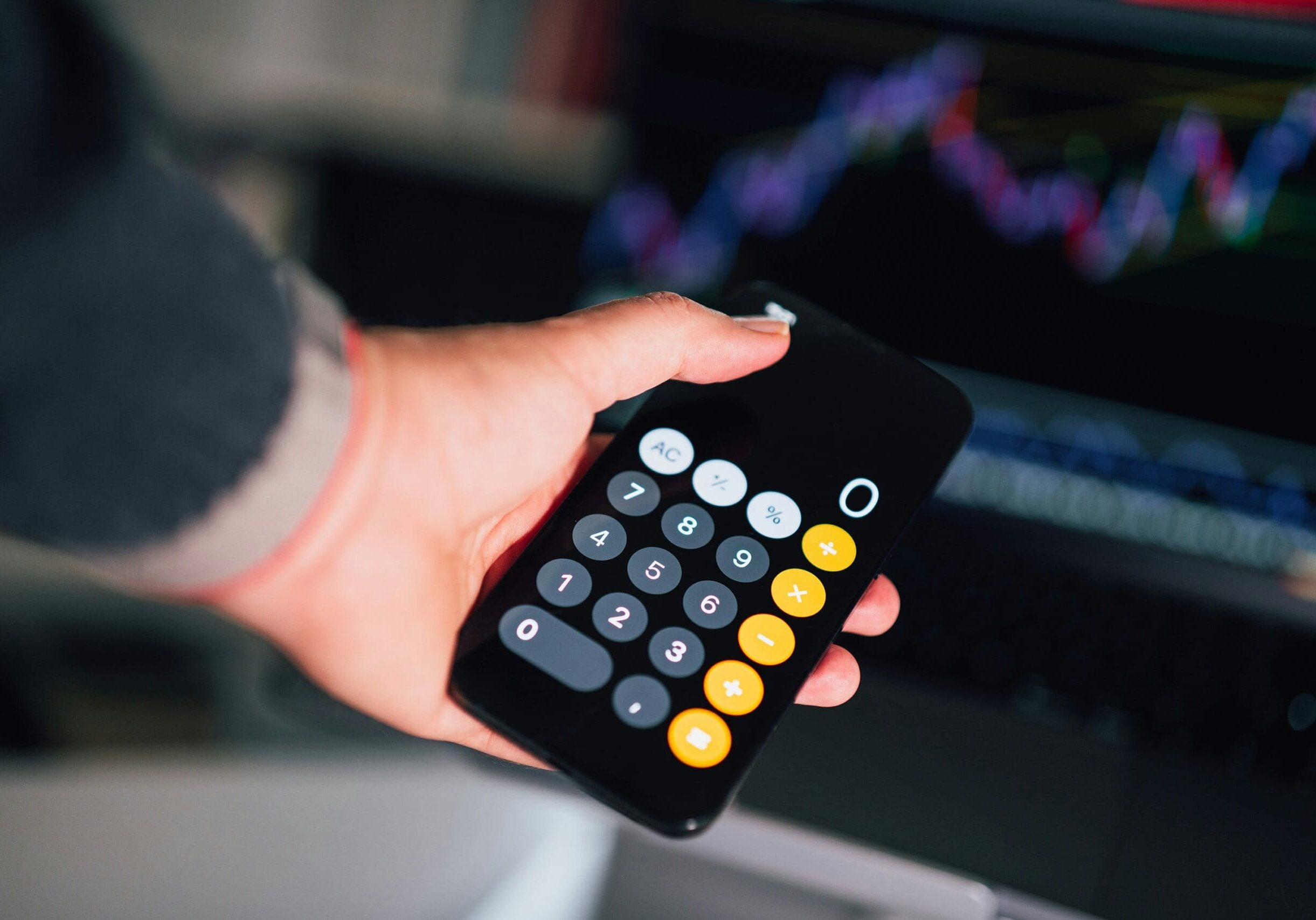 person holding phone calculator showing number zero to depict net-zero emissions